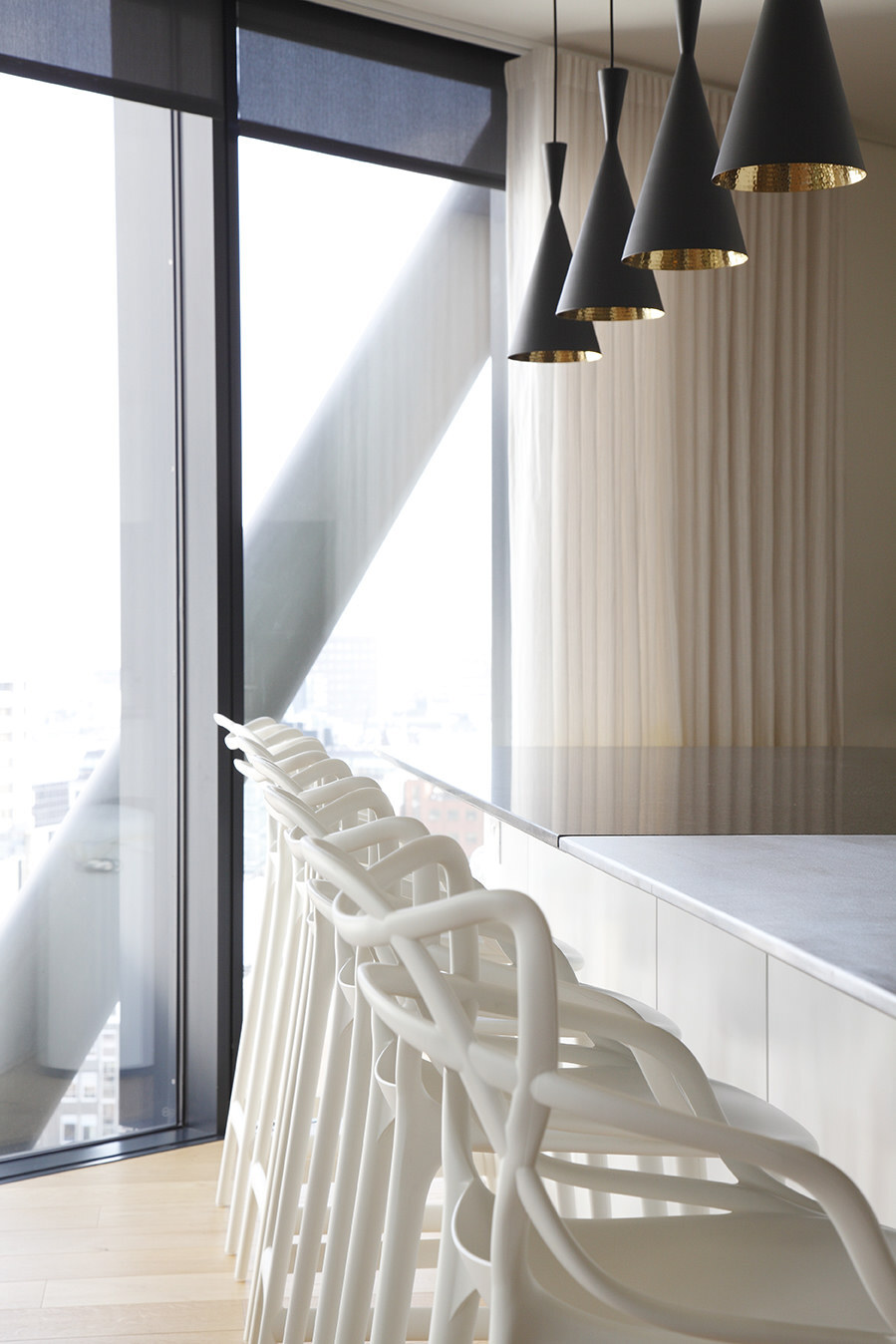 Contemporary penthouse kitchen bar with black/gold pendants