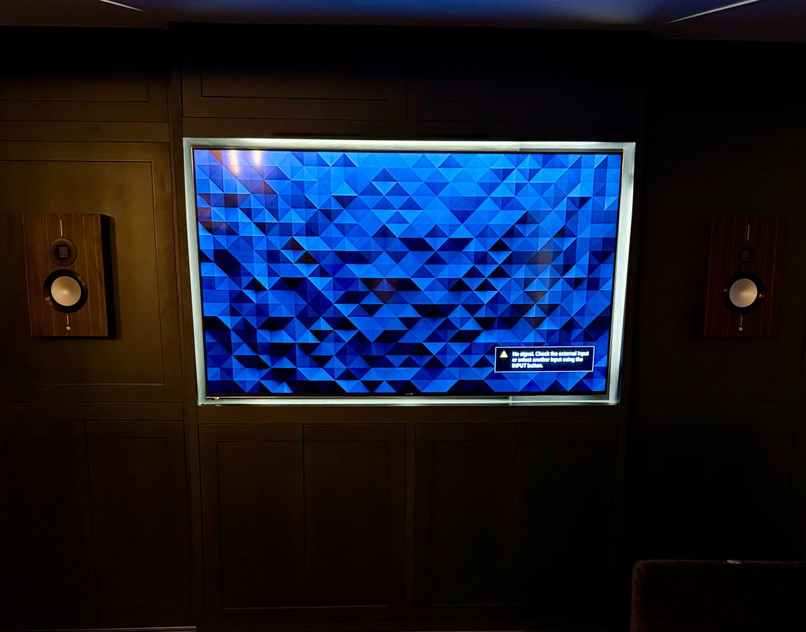 Dark panelled media wall with embedded speakers and inset TV