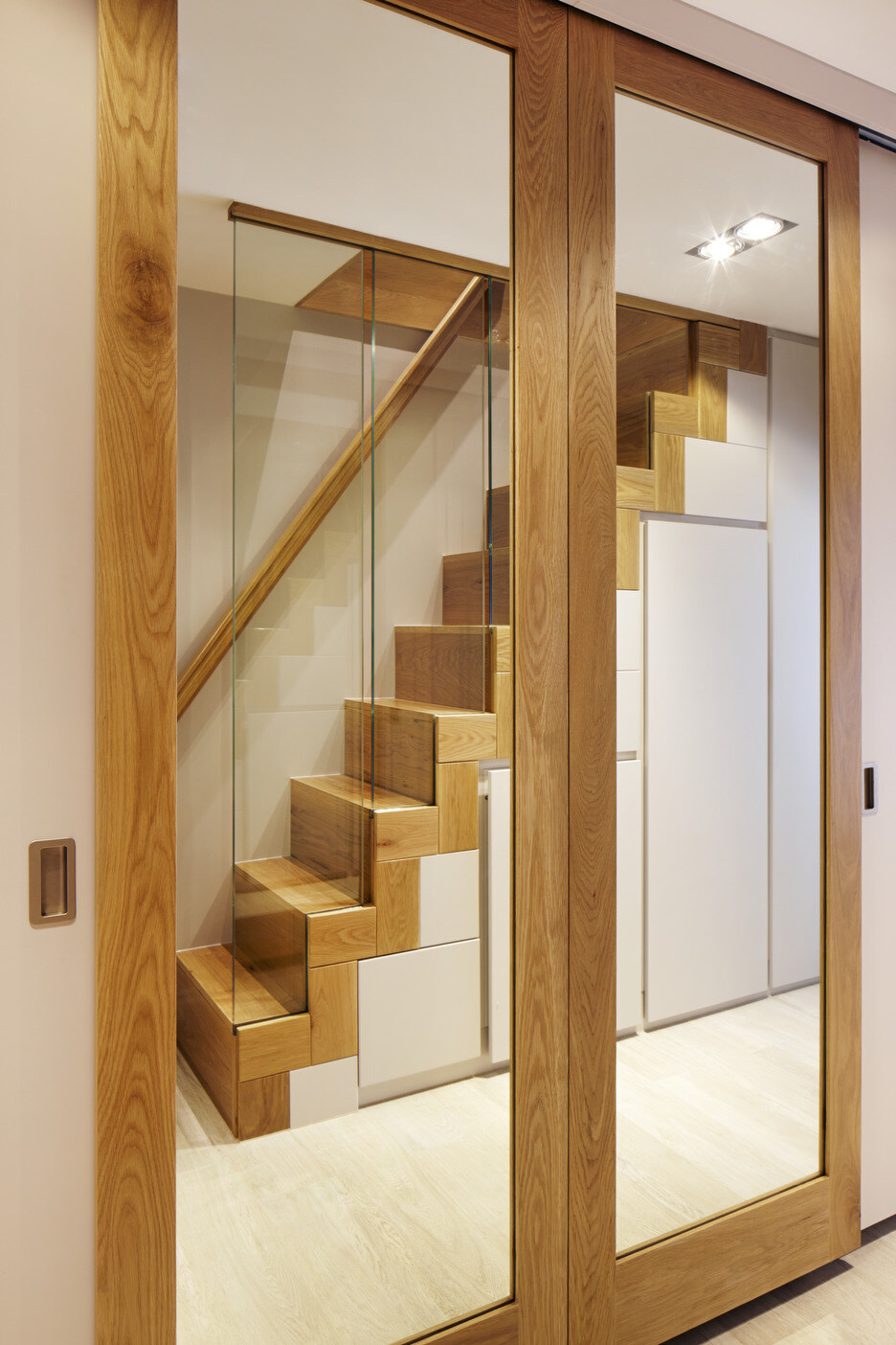 Oak-framed mirror doors with view to staircase joinery