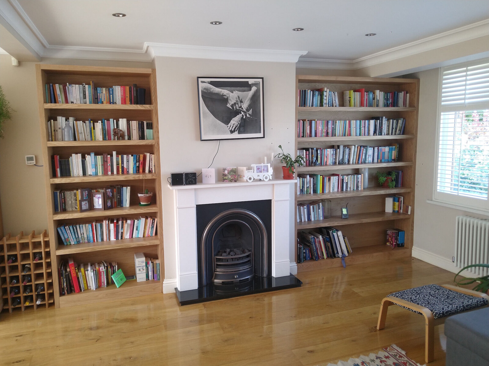Bespoke oak alcove bookcases flanking a Victorian fireplace