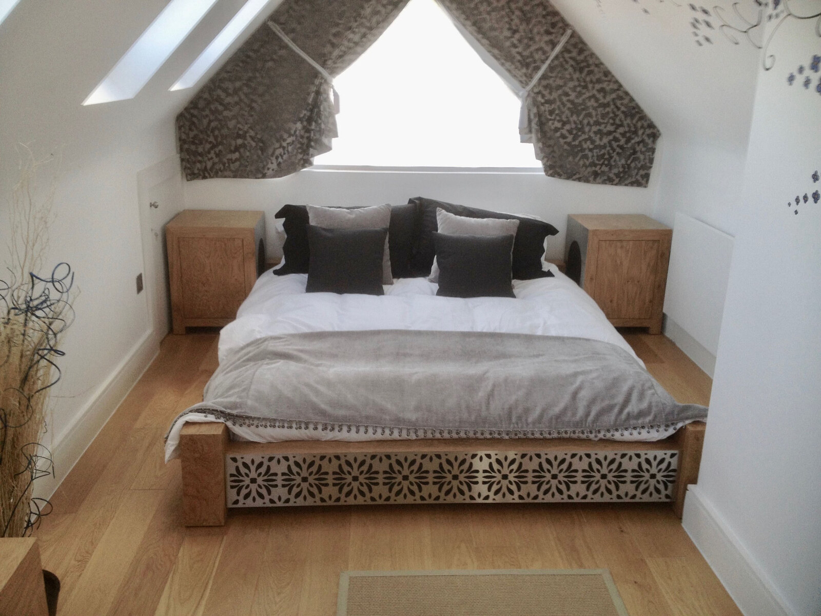 Bespoke oak attic bedroom with cut-out footboard bed and nightstands