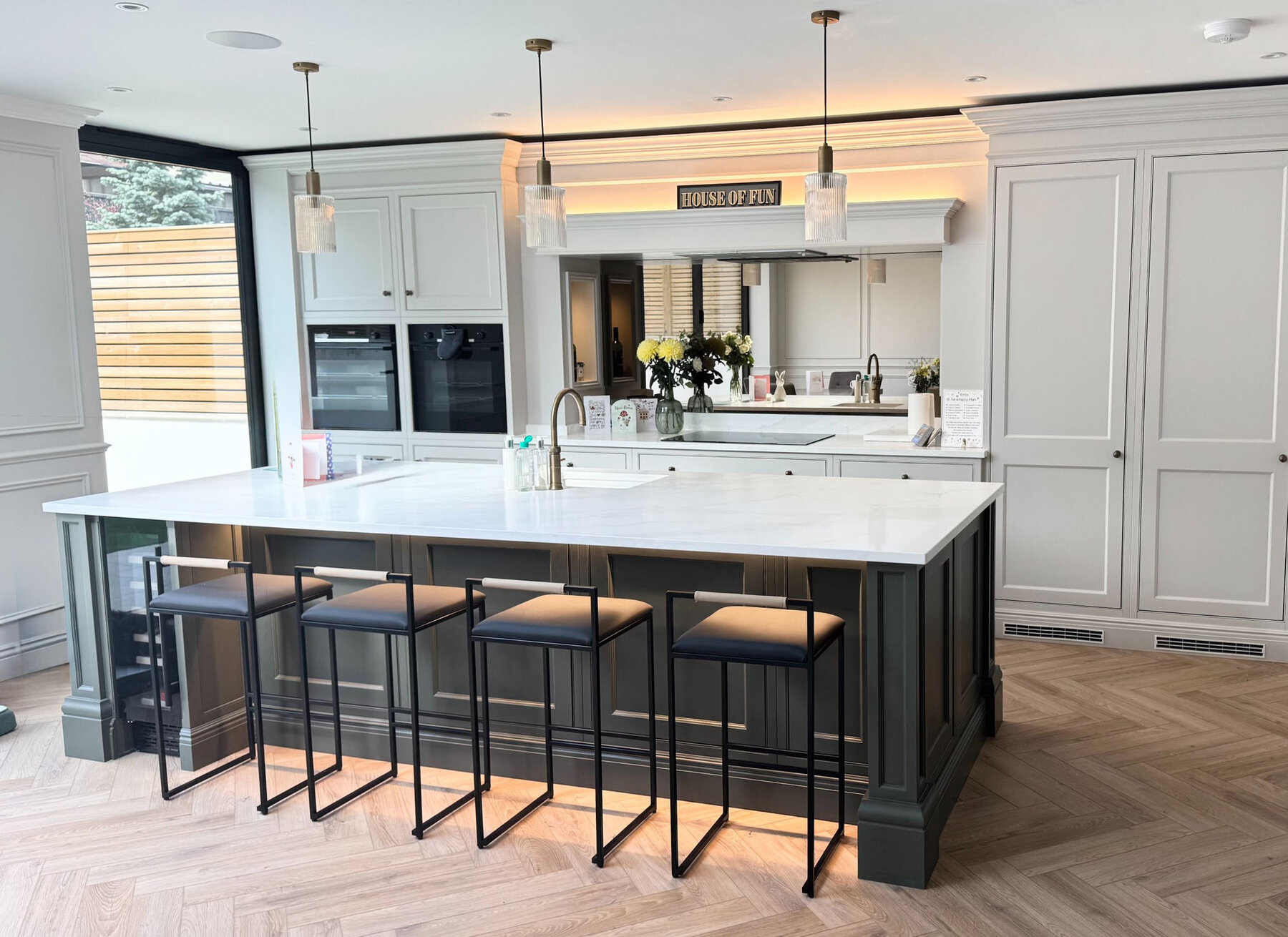 Shaker kitchen with charcoal island, marble worktop and brass pendants