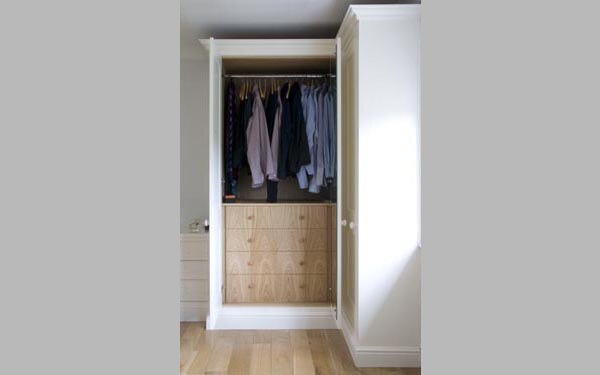 Open fitted wardrobe interior with oak drawers